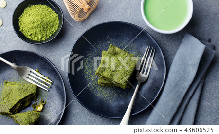 Matcha green tea cake, bars, brownie with white chocolate on a plate. Grey background. Top view. Matcha green tea cake, bars, brownie with white chocolate on a plate. Grey background. Top view. 43606525