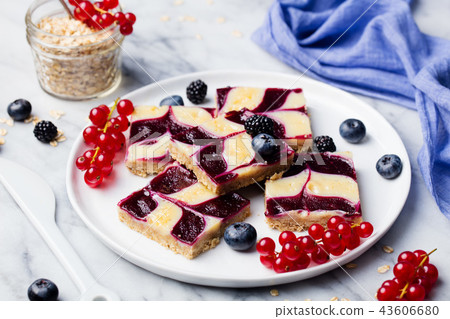 Oatmeal, oat bars with fresh berries on a white plate. Marble background. Healthy breakfast. 43606680