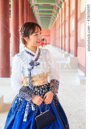 A woman wearing a hanbok in a corridor of Kyeongbok Palace A woman wearing a hanbok in a corridor of Kyeongbok Palace 43609895