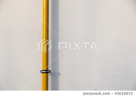 Yellow gas pipe in front of residential building wall 43610633