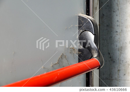 Closed up latch and door handle of emergency exit. Push bar and rail for panic exit. 43610666