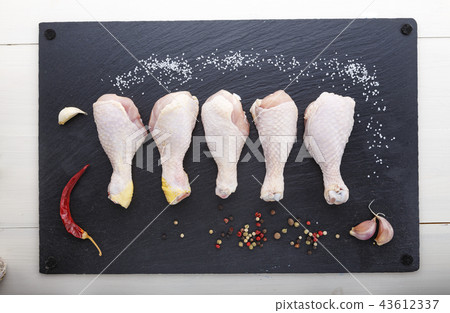 raw chicken legs in a row and spices raw chicken legs in a row and spices 43612337