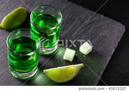 Two glasses of absinthe with lime slices and pieces of sugar Two glasses of absinthe with lime slices and pieces of sugar 43613287