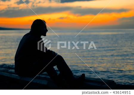 guy standing by the sea at sunset guy standing by the sea at sunset 43614951