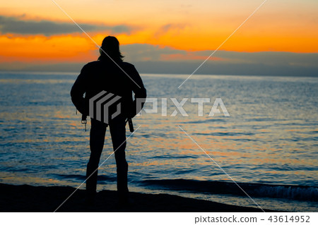 guy standing by the sea at sunset guy standing by the sea at sunset 43614952