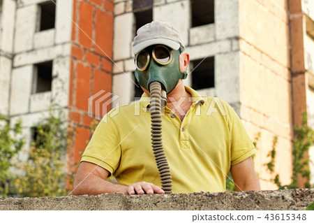 Men in vintage gas mask against ruined building. 43615348