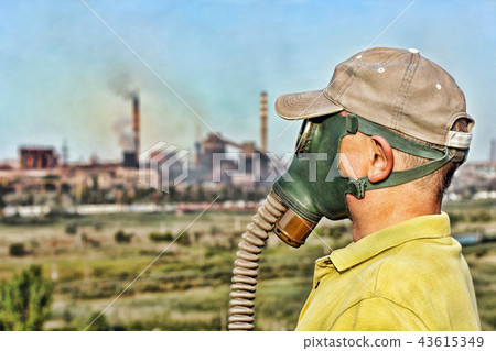 Men in gas mask against industrial smoking pipe. 43615349