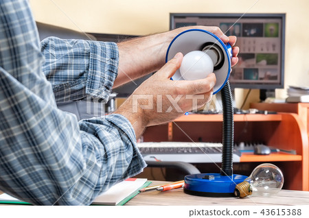 Electrician technician at work installs led bulb Electrician technician at work installs led bulb 43615388