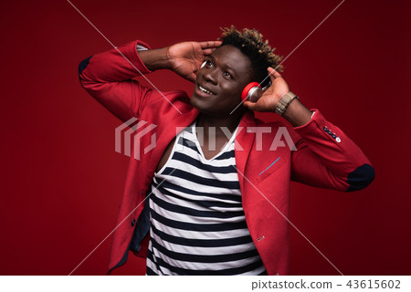 Joyful man listening music on red background 43615602
