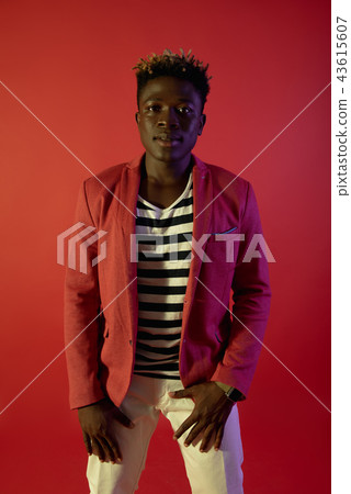 Stylish man is posing on red background Stylish man is posing on red background 43615607