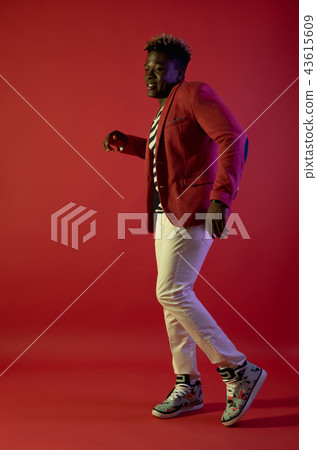 Cheerful man is dancing on red background 43615609