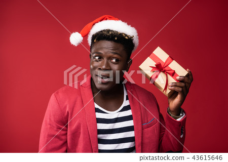 Joyful man is holding gift box with red ribbon Joyful man is holding gift box with red ribbon 43615646