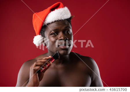 Shirtless man shaving in studio and looking at camera 43615700