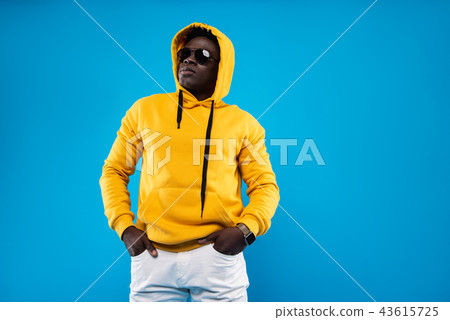 Serious guy in sunglasses posing on blue background 43615725