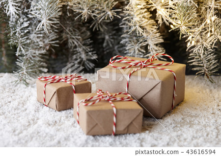 Christmas gift boxes wrapped in paper under tree Christmas gift boxes wrapped in paper under tree 43616594