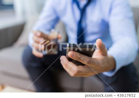 man with smartphone and glass of alcohol at home man with smartphone and glass of alcohol at home 43617652