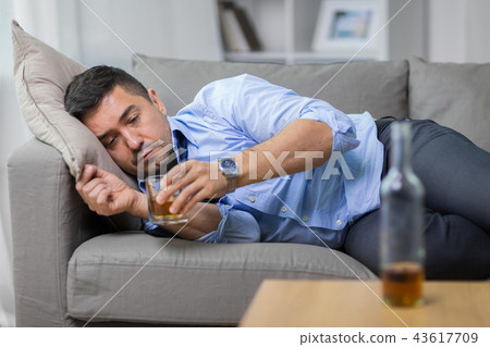 alcoholic lying on sofa and drinking whiskey 43617709
