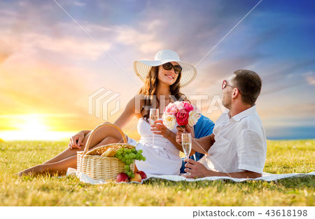 couple with flowers drinking champagne at picnic couple with flowers drinking champagne at picnic 43618198