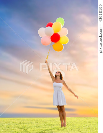 woman in sunglasses with balloons over sunset sky woman in sunglasses with balloons over sunset sky 43618199