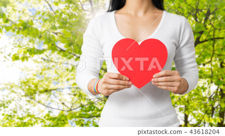 woman with gay awareness wristband holding heart woman with gay awareness wristband holding heart 43618204