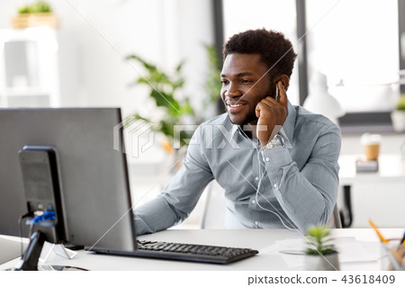 businessman with earphones and computer at office 43618409