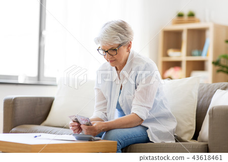 senior woman counting money at home senior woman counting money at home 43618461