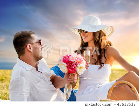 couple with flowers drinking champagne at picnic 43618532