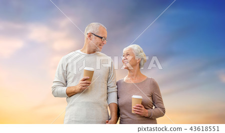 happy senior couple with coffee over evening sky happy senior couple with coffee over evening sky 43618551