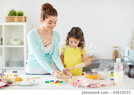 happy mother and daughter making cookies at home 43618555