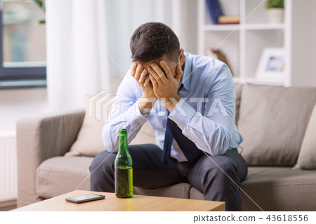 male alcoholic with bottle of beer at home male alcoholic with bottle of beer at home 43618556