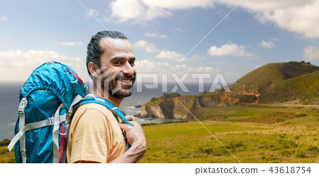 close up of man with backpack over big sur coast 43618754