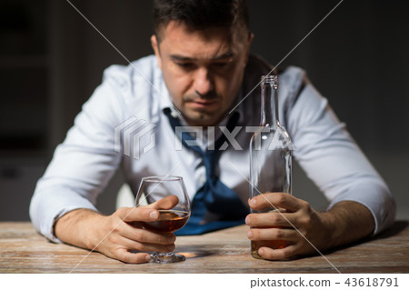 drunk man drinking alcohol at table at night 43618791