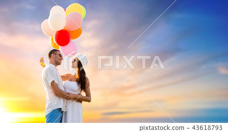happy couple with balloons over sunset sky happy couple with balloons over sunset sky 43618793