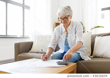 senior woman with money and bills at home senior woman with money and bills at home 43618834