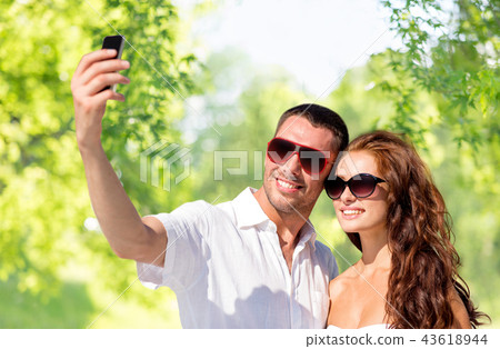 smiling couple making selfie by smartphone smiling couple making selfie by smartphone 43618944