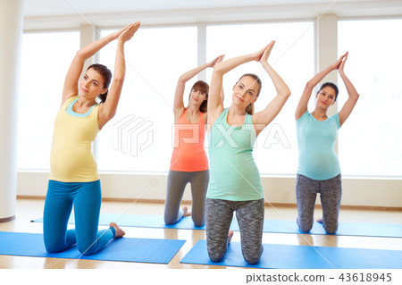 happy pregnant women exercising on mats in gym happy pregnant women exercising on mats in gym 43618945
