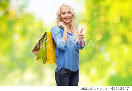 young woman with shopping bags showing thumbs up young woman with shopping bags showing thumbs up 43618947