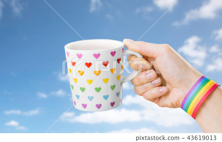 hand with cup of cacao and gay awareness wristband hand with cup of cacao and gay awareness wristband 43619013