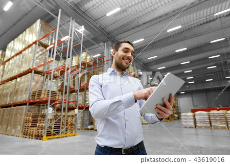 happy businessman with tablet pc at warehouse 43619016