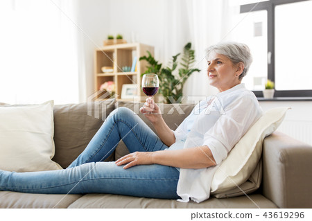 senior woman with glass of red wine at home 43619296