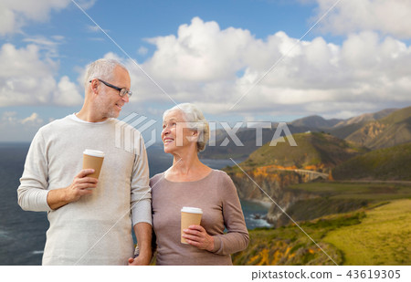 senior couple with coffee cups over big sur coast senior couple with coffee cups over big sur coast 43619305