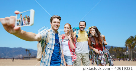 friends with backpack taking selfie by smartphone friends with backpack taking selfie by smartphone 43619321