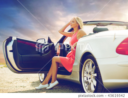 woman in convertible car over evening sky woman in convertible car over evening sky 43619342