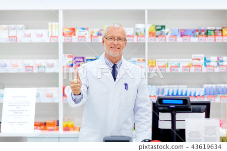 senior apothecary at pharmacy showing thumbs up senior apothecary at pharmacy showing thumbs up 43619634