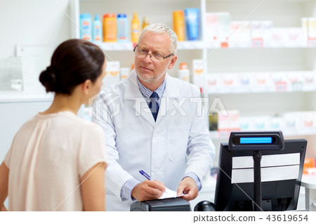 senior apothecary with prescription at pharmacy 43619654