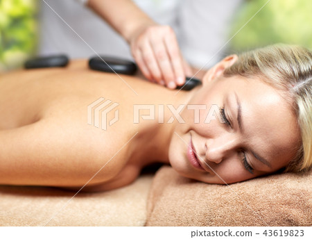 close up of woman having hot stone massage in spa 43619823