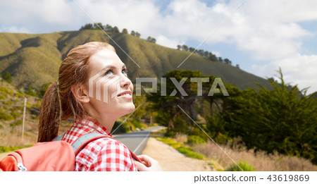 smiling woman with backpack over big sur hills 43619869