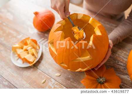 close up of woman carving halloween pumpkin close up of woman carving halloween pumpkin 43619877