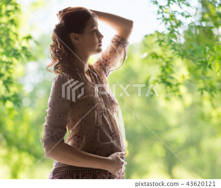 pregnant woman over green natural background pregnant woman over green natural background 43620121