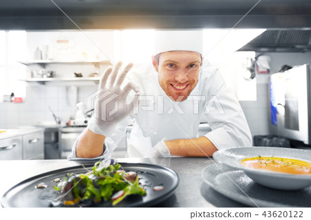 happy male chef cooking food at restaurant kitchen happy male chef cooking food at restaurant kitchen 43620122